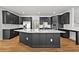 A modern kitchen features dark cabinets with gold hardware and a large kitchen island with quartz countertop at 1303 Angel Falls Sw Ln, Atlanta, GA 30311