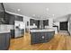 Open-concept kitchen with black cabinets, island with white countertop, stainless steel appliances, and hardwood floors at 1303 Angel Falls Sw Ln, Atlanta, GA 30311