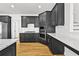 A modern kitchen featuring dark cabinets, stainless steel appliances, and quartz countertops at 1303 Angel Falls Sw Ln, Atlanta, GA 30311