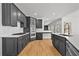 Modern kitchen with black cabinets, stainless steel appliances, quartz countertops, and hardwood floors at 1303 Angel Falls Sw Ln, Atlanta, GA 30311