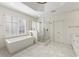 Sunlit bathroom featuring a freestanding tub, glass shower, white cabinetry, and modern fixtures at 1386 Wesley Nw Cir, Atlanta, GA 30327