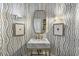 Stylish powder room with unique wallpaper, framed art, gold accents, and a marble sink at 1386 Wesley Nw Cir, Atlanta, GA 30327