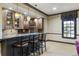 Stylish wet bar area with wooden cabinets, stone countertops, and seating for four at 1386 Wesley Nw Cir, Atlanta, GA 30327