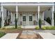 Inviting front porch with stylish seating, framed by elegant columns and lush landscaping, perfect for relaxing outdoors at 375 Banbury Xing, Alpharetta, GA 30009