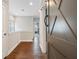 Hallway with hardwood floors and access to multiple rooms, featuring a gray barn door at 375 Banbury Xing, Alpharetta, GA 30009