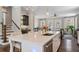 Open-concept kitchen island with stainless steel dishwasher, seating, and stylish pendant lighting overlooking the living room at 375 Banbury Xing, Alpharetta, GA 30009
