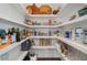 Walk-in pantry with white shelving and plenty of space for storing groceries and kitchen gadgets at 375 Banbury Xing, Alpharetta, GA 30009