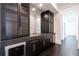 Elegant bar area with dark cabinetry, granite countertops, and a wine fridge, ideal for entertaining guests at 5211 Powers Ferry Rd, Sandy Springs, GA 30327