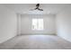 Bright, carpeted bedroom features a modern ceiling fan, recessed lighting, and a large window with a pleasant view at 5211 Powers Ferry Rd, Sandy Springs, GA 30327