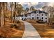 Elegant white home featuring a circular driveway and manicured lawn at 5211 Powers Ferry Rd, Sandy Springs, GA 30327