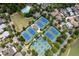 Aerial view showcasing community tennis courts and a swimming pool amidst tree-lined streets at 7285 Cordery Rd, Cumming, GA 30040