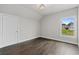 Clean bedroom with hardwood floors with a large window overlooking exterior lawn space at 7285 Cordery Rd, Cumming, GA 30040