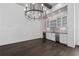 Dining area showcases a chandelier, wood floors, and a built-in bar with a beverage cooler at 7285 Cordery Rd, Cumming, GA 30040