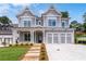 Beautiful two-story home with gray siding, white trim, a front porch, three-car garage and manicured front yard at 7285 Cordery Rd, Cumming, GA 30040