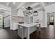 Modern kitchen with an island, white cabinets, stainless steel appliances, and hardwood floors is brightly lit at 7285 Cordery Rd, Cumming, GA 30040