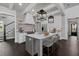 Modern kitchen with an island, white cabinets, stainless steel appliances, and hardwood floors is brightly lit at 7285 Cordery Rd, Cumming, GA 30040