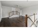 The large open loft has dark hardwood floors, white railings, and a ceiling fan at 7285 Cordery Rd, Cumming, GA 30040