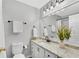 Bright bathroom featuring single vanity with granite counters, framed mirror, and white cabinets at 2283 Stratmor Dr, Tucker, GA 30087