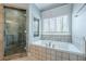 Bright bathroom with a tiled shower, tub, and large window at 2647 Brickell Sq, Atlanta, GA 30341