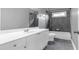 Well-lit bathroom featuring a modern vanity with granite countertops and tub with dark tile at 2647 Brickell Sq, Atlanta, GA 30341