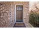 Close-up of the entryway with a classic wooden door framed by brick and a 'Welcome' mat at 2647 Brickell Sq, Atlanta, GA 30341
