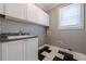 Functional laundry room featuring white cabinets, a sink, and black-and-white tiled floors at 2647 Brickell Sq, Atlanta, GA 30341