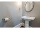 Simple powder room featuring a pedestal sink, round mirror, and modern fixtures at 2647 Brickell Sq, Atlanta, GA 30341