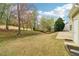 Large backyard with lush green lawn, mature trees, and partial home exterior at 6945 W Mountain Xing, Cumming, GA 30041