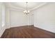 Dining room with paneled walls, hardwood floors, and a stylish chandelier at 6945 W Mountain Xing, Cumming, GA 30041