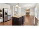 Kitchen featuring an island, stainless steel appliances, white cabinets, and hardwood floors at 6945 W Mountain Xing, Cumming, GA 30041