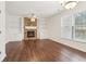 Spacious living room with stone fireplace, built-in shelving, ceiling fan, and hardwood floors at 6945 W Mountain Xing, Cumming, GA 30041