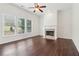 Bright living room featuring dark hardwood floors, a fireplace, and large windows overlooking the outdoors at 6945 W Mountain Xing, Cumming, GA 30041