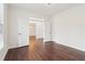Bright living room with hardwood floors, white walls, and an open doorway to the dining area at 6945 W Mountain Xing, Cumming, GA 30041