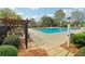 Community pool with a pergola-covered picnic area and ample seating, surrounded by trees and greenery at 6945 W Mountain Xing, Cumming, GA 30041