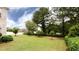 Large backyard featuring green lawn, small trees, and manicured shrubs, ideal for relaxation at 1236 Saxony Se Dr, Conyers, GA 30013