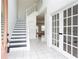 Bright foyer featuring tile flooring, staircase, and French doors leading to other rooms at 1236 Saxony Se Dr, Conyers, GA 30013