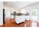 Open kitchen with white cabinets, stainless steel appliances, black countertops, and a mobile island at 1236 Saxony Se Dr, Conyers, GA 30013