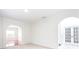 Open-concept living room with neutral carpet, arched doorways, and decorative trim at 1236 Saxony Se Dr, Conyers, GA 30013