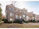 Charming brick townhome with multiple stories, tidy landscaping, and inviting front entrances along the sidewalk at 3032 Hartford Mill Pl, Duluth, GA 30097
