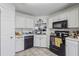 The kitchen features white cabinets and black appliances, along with a view of the living room at 3080 Autumn Woods Ct, Douglasville, GA 30135