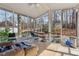 Screened-in sunroom with tile flooring, ceiling fan, and backyard views through the large windows at 3080 Autumn Woods Ct, Douglasville, GA 30135