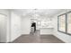 Dining room area with gray floors adjacent to an open kitchen, both with ample lighting at 441 Pomona Sw Cir, Atlanta, GA 30315