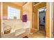 Bright bathroom featuring a large bathtub with a window and a glimpse into the walk-in closet at 4230 Spur Look Xing, Douglasville, GA 30135