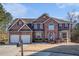Charming two-story brick home featuring a two-car garage and professionally landscaped front yard at 4230 Spur Look Xing, Douglasville, GA 30135