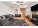 A modern living room with dark sofas, a fireplace, stairs, and a ceiling fan at 4230 Spur Look Xing, Douglasville, GA 30135