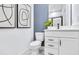 Modern bathroom with white vanity, blue accent wall, modern mirror, and toilet at 5410 Julep Ct, Cumming, GA 30028