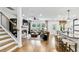 Bright living room showcases a cozy fireplace, wooden staircase, stylish kitchen and plenty of natural light at 5410 Julep Ct, Cumming, GA 30028