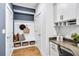 Mudroom with bench, storage cubbies, coat hooks, and a desk nook with granite counters and white cabinets at 5410 Julep Ct, Cumming, GA 30028