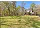 Expansive backyard with mature trees, a cozy patio, and gazebo ideal for entertaining at 8078 Longleaf Dr, Villa Rica, GA 30180