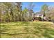 Large, well-maintained backyard with mature trees, a deck, a gazebo, and ample space for recreation and relaxation at 8078 Longleaf Dr, Villa Rica, GA 30180
